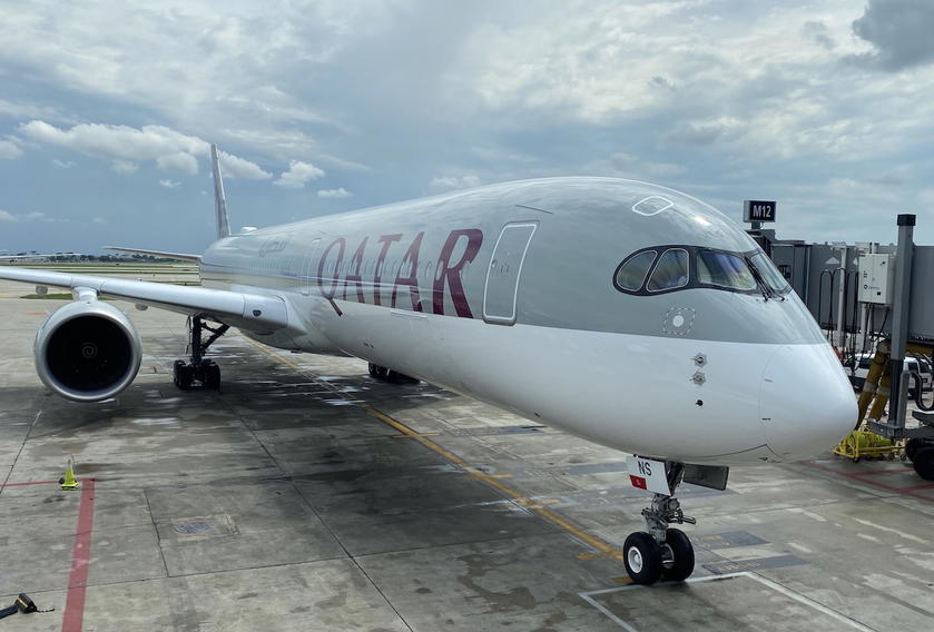 Qatar Airways Airbus A350-1000 parked at an airport gate