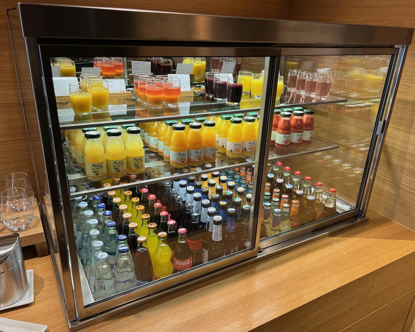 Refrigerated display with water, soda, juice, beer, and smoothies in the SWISS First Lounge Zurich