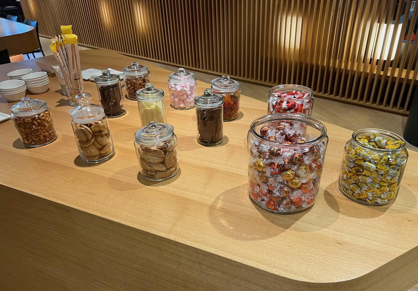 Table of sweet and savory snacks like chocolates and nuts in the SWISS First Lounge Zurich