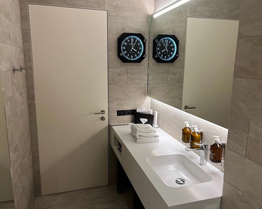 Walk-in shower and sink inside a SWISS First Lounge Zurich shower suite