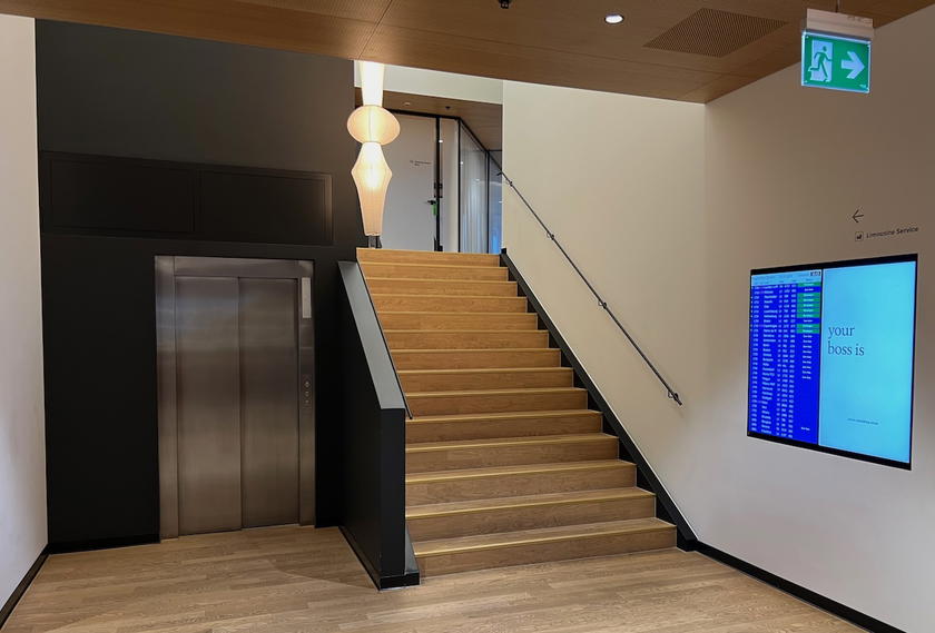 Staircase and elevator leading to the upper level of the SWISS First Lounge Zurich Terminal A