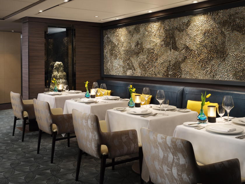 Specialty dining restaurant aboard a Ritz-Carlton Yacht Collection ship with set tables and ocean views