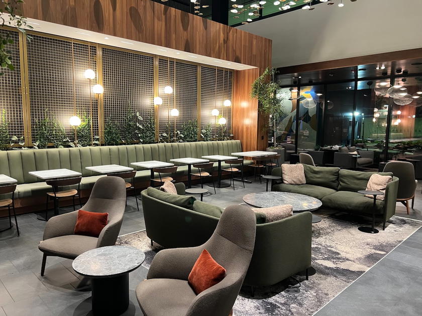 Seating area with dining tables inside the Amex Centurion Lounge in Atlanta