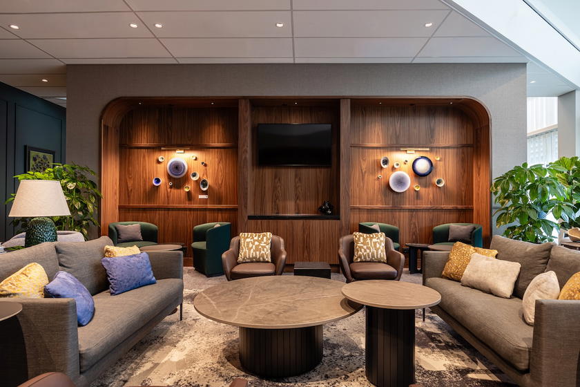 Seating area with armchairs and floor-to-ceiling windows in the Amex Centurion Lounge Amsterdam