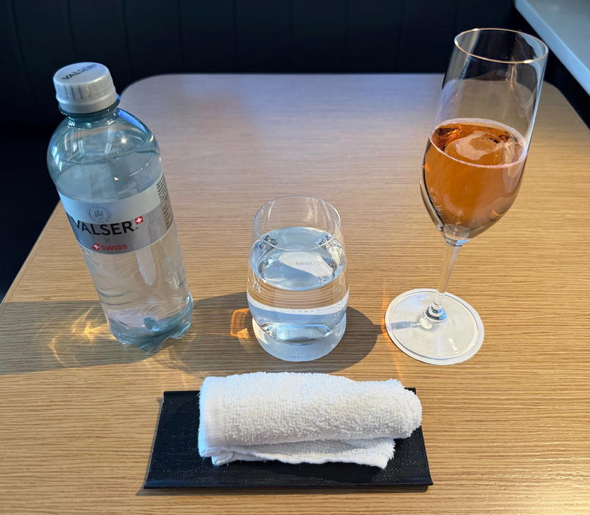 Glass of champagne and warm towel served before departure in SWISS first class