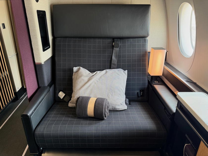 Wide view of SWISS first class suite 1A showing the seat and ottoman
