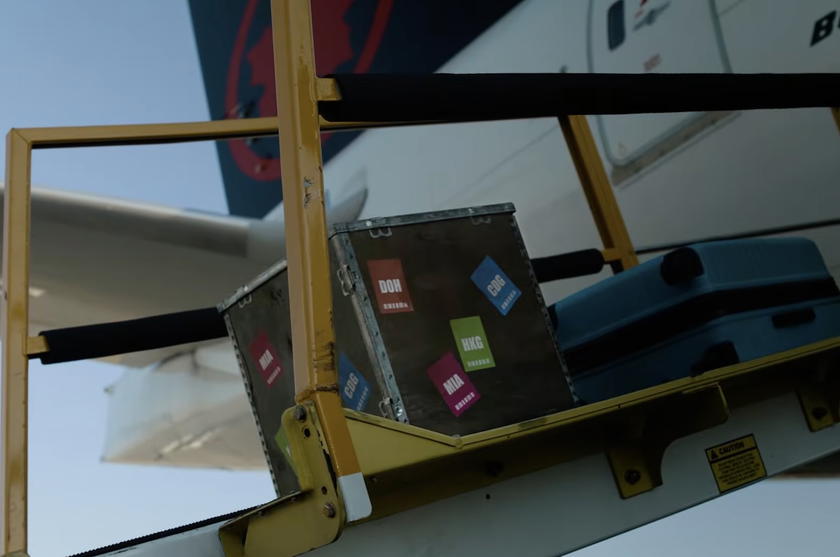 Square cargo container with airport codes being loaded onto an Air Canada plane