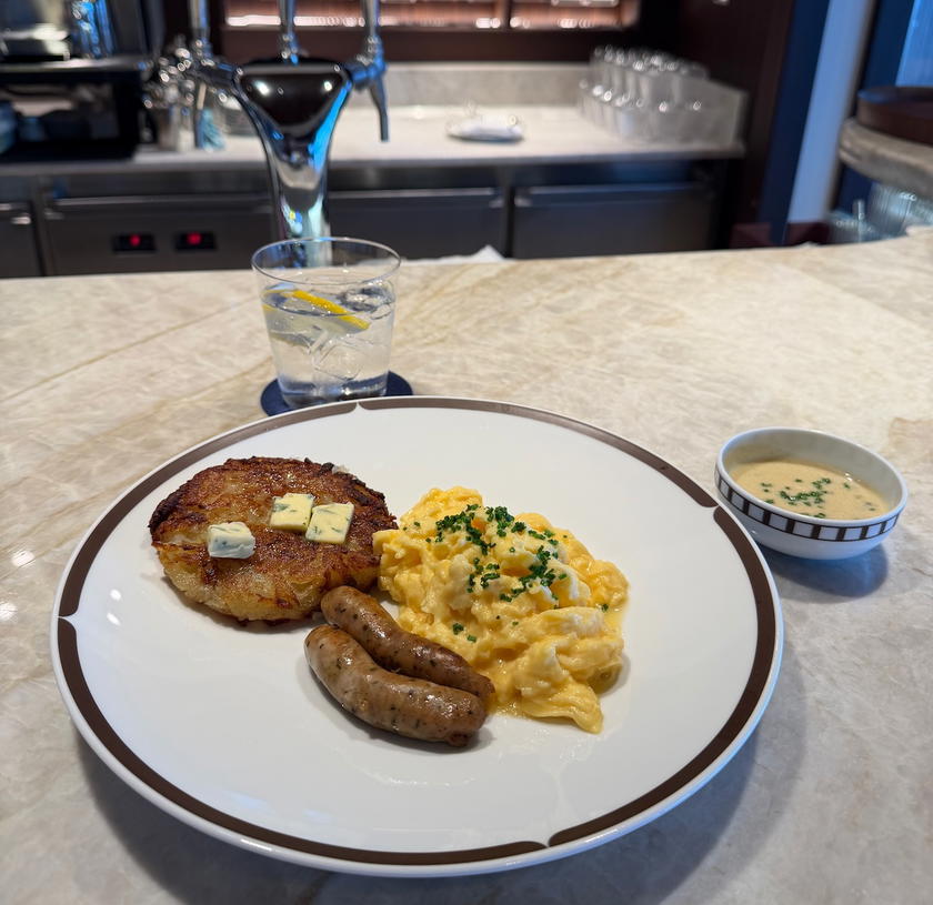 Breakfast plate of scrambled eggs, sausage, avocado, and caviar sauce aboard Orient Express Corinthian