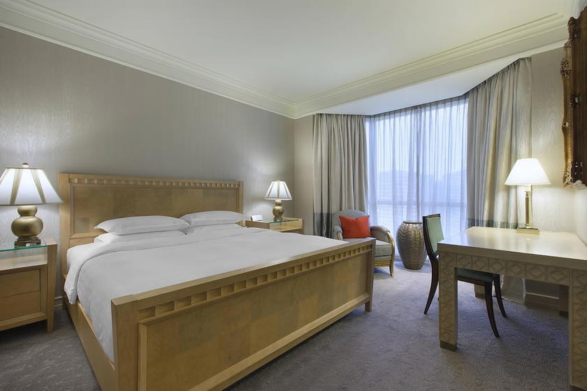 Guest room interior at the Sheraton Towers Singapore with a bed and city view window