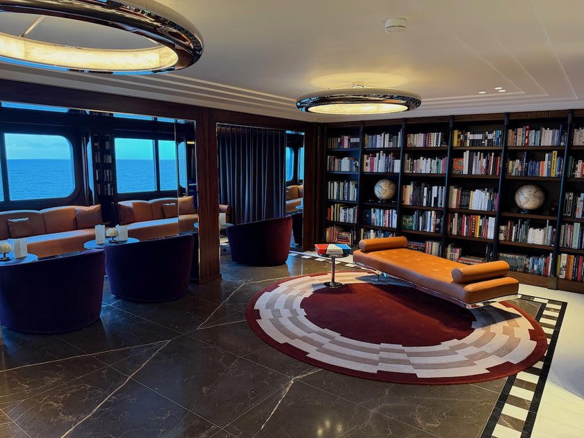 Library lounge aboard the Corinthian with bookshelves and seating