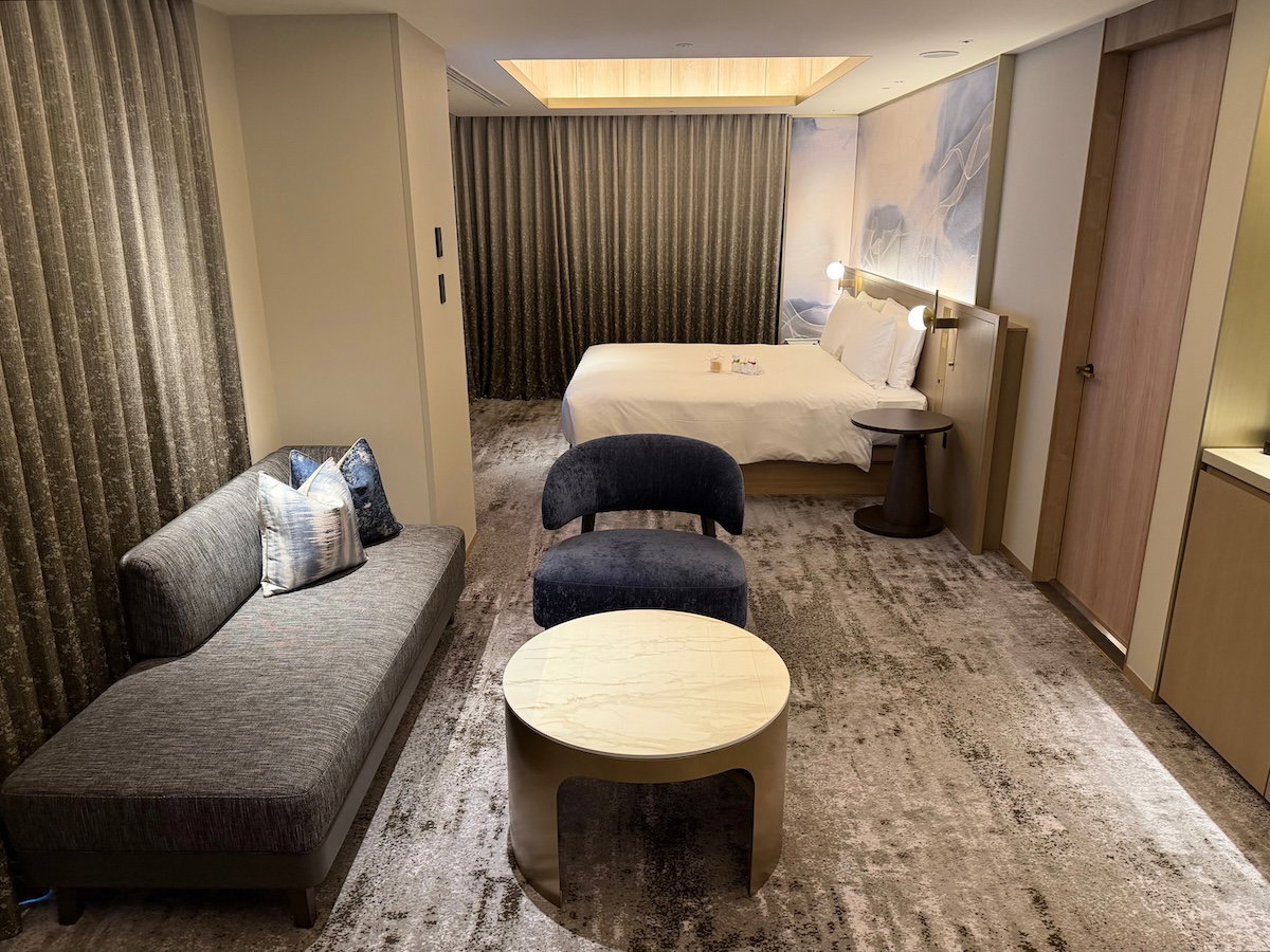 Layout of the scenic corner king room with living area by the entrance and bed at the back