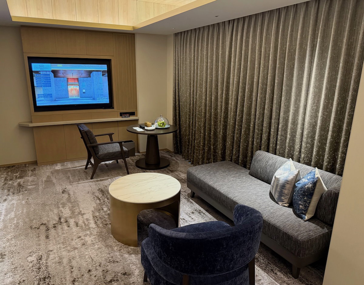 Room sitting area with a chair, daybed and wall-mounted TV