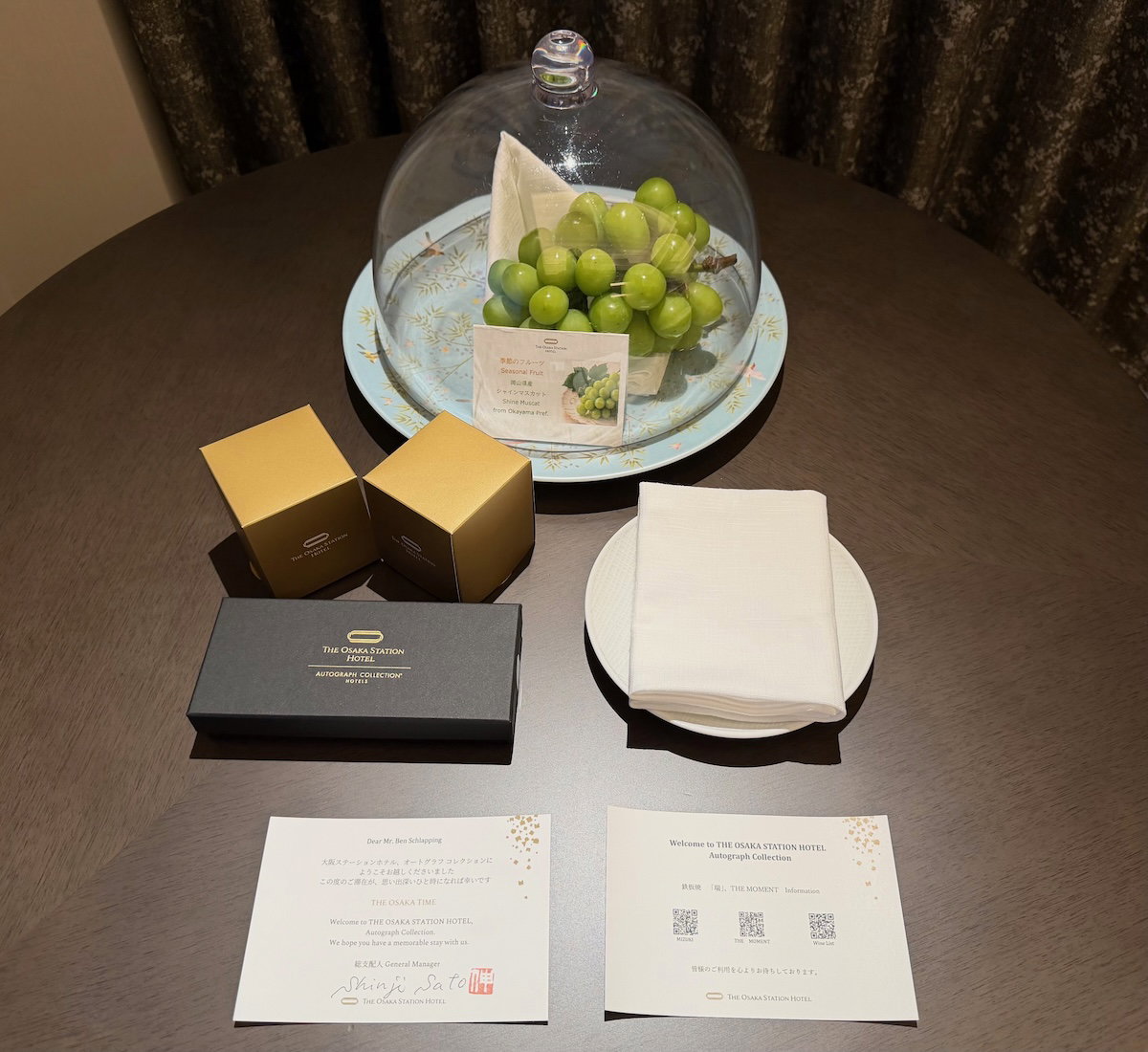 Welcome amenity of grapes and sweets with a personalized note on the bed