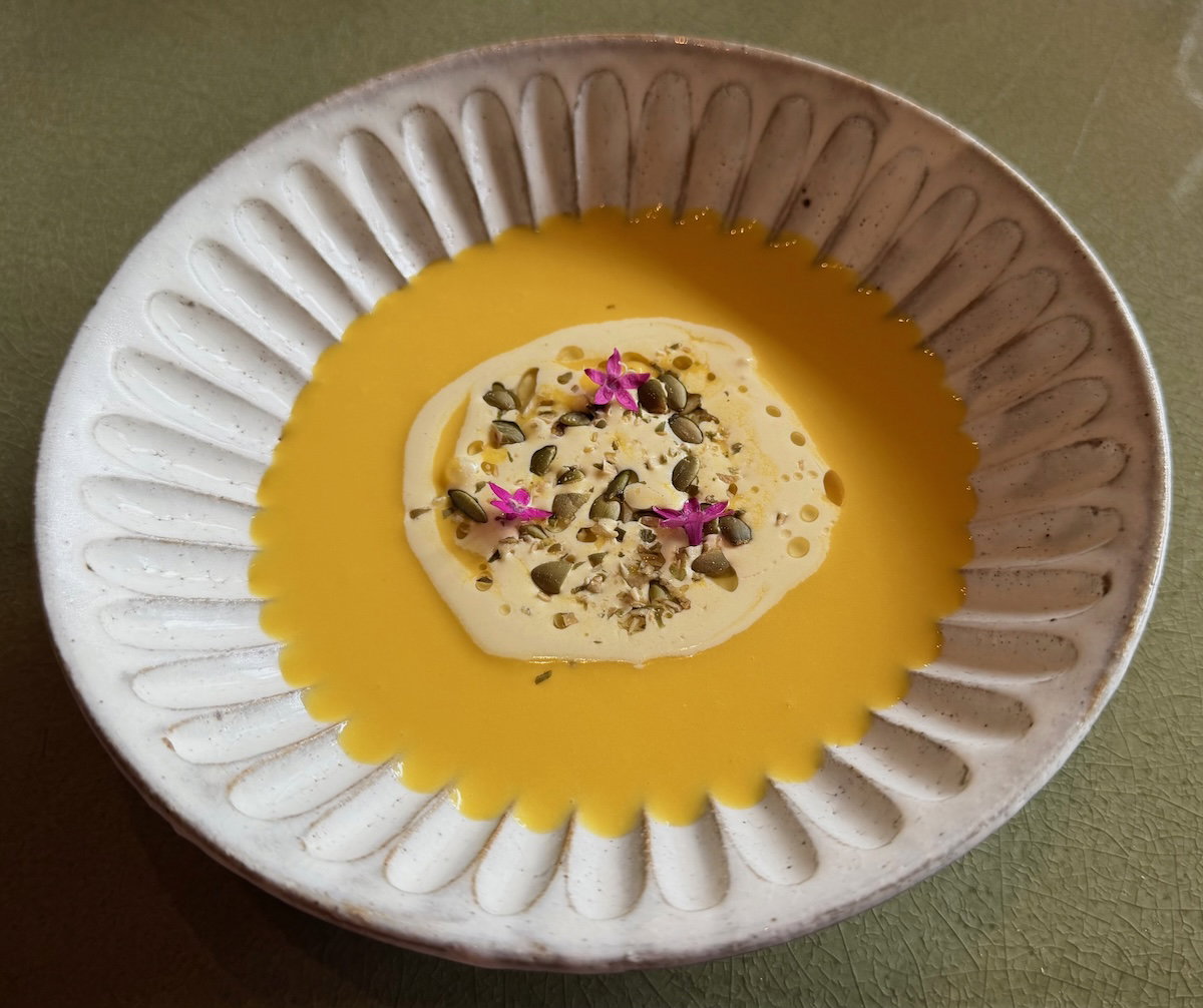 Chilled pumpkin soup with saffron soy milk cream at P72