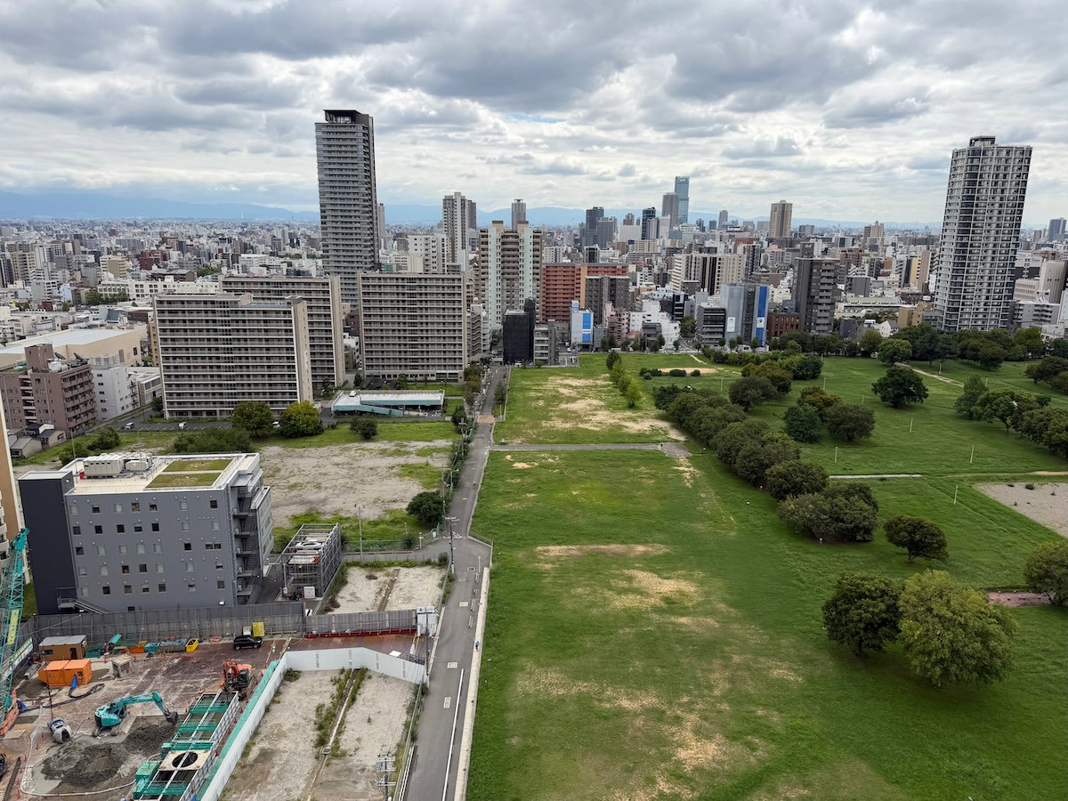 City-facing view from a Patina Osaka room, with the highway below and buildings in the distance
