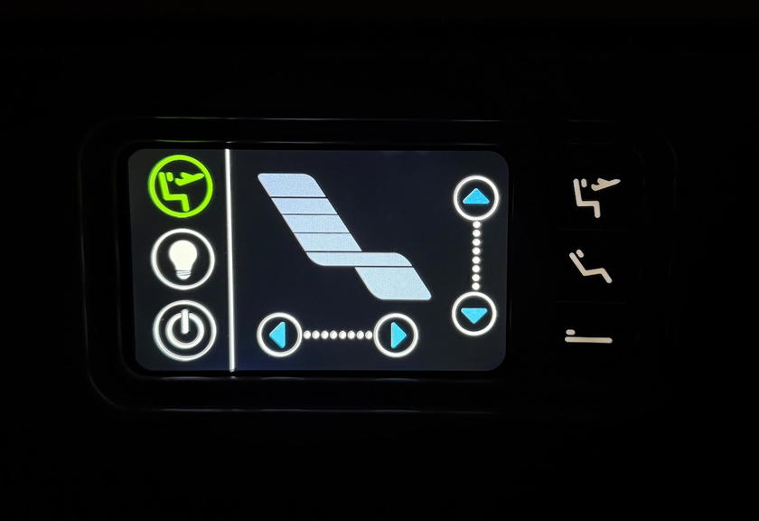 Control panel for seat recline and lighting next to the storage compartment