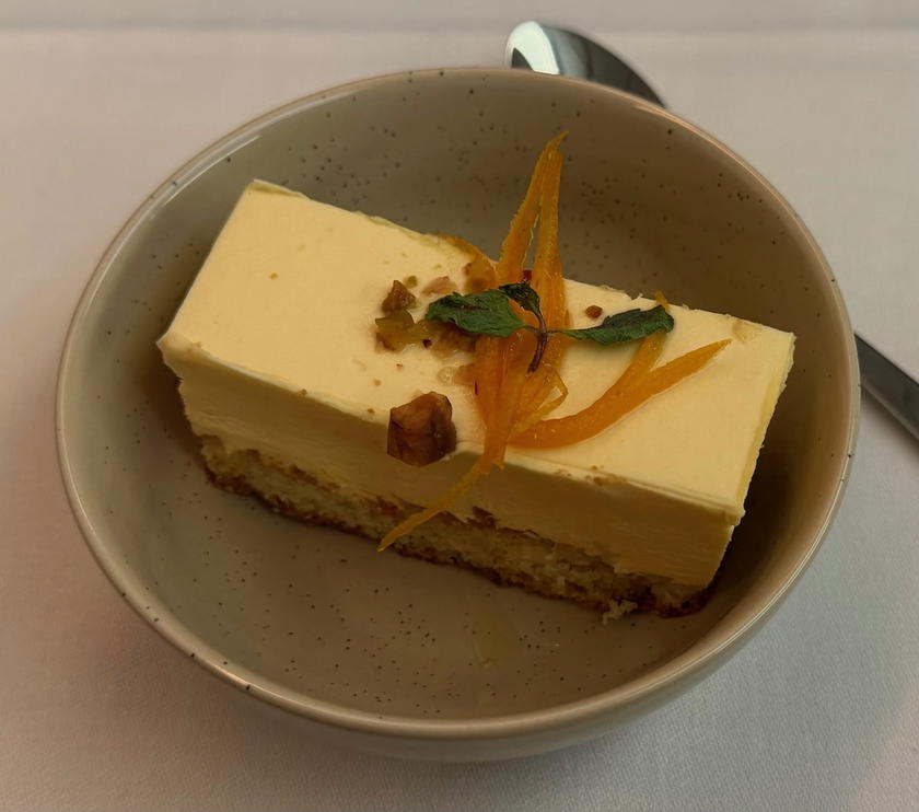 Orange yogurt mousse cake with pistachio crumble and candied orange peel