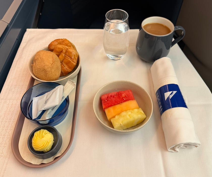 Breakfast table setting with a fruit appetizer and a breadbasket