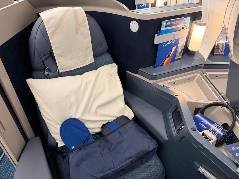 Side console beside the Philippine Airlines A350 business class seat with a wireless charging pad
