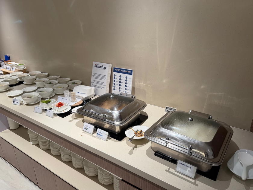 Buffet trays with rice and main dishes in the Mabuhay Lounge