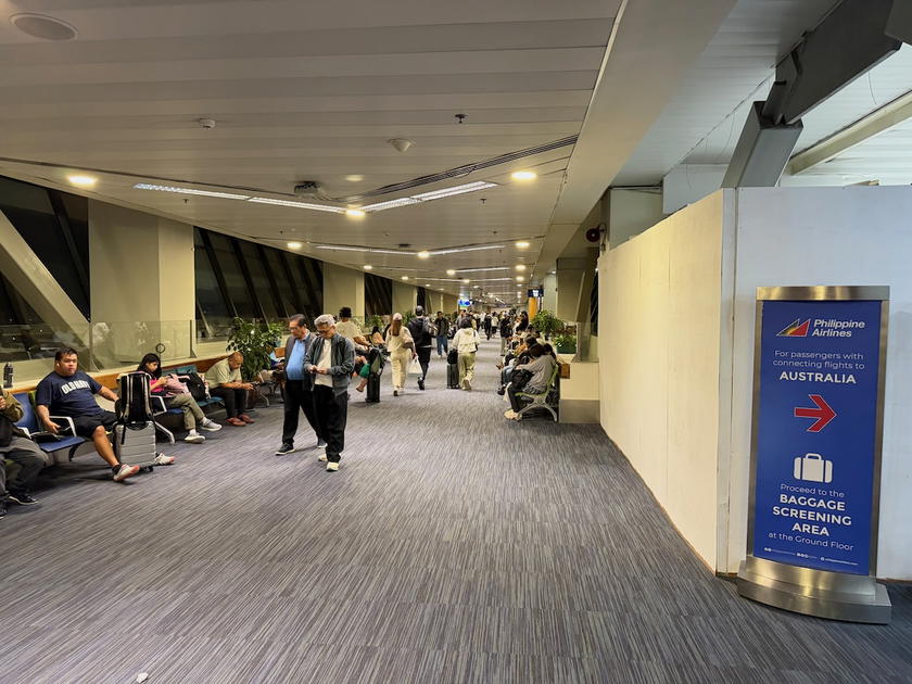 Signs for Australia flights and the Mabuhay Lounge side by side in Manila Terminal 1