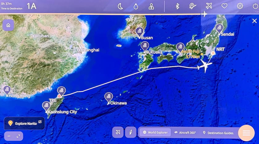 Seatback entertainment screen showing the flight map as the plane nears Tokyo
